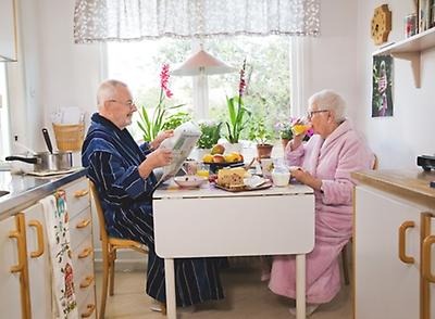 Äldre par som sitter vid bord tillsammans