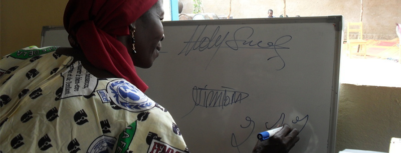 Deltagare tränar på att skriva sin namnteckning. Foto: IOM